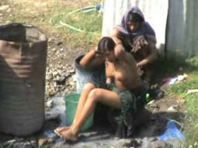 Exotic girls take an outdoor shower in public